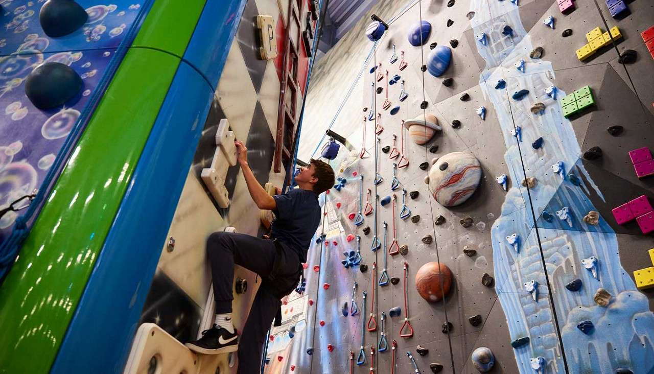 A teenage boy on the indoor climbing wall.