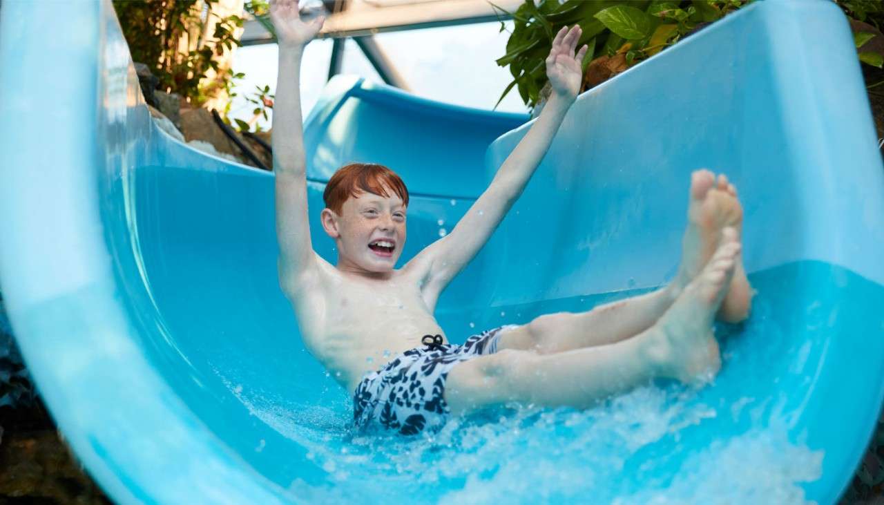 A boy going down a Flume in the Subtropical Swimming Paradise.