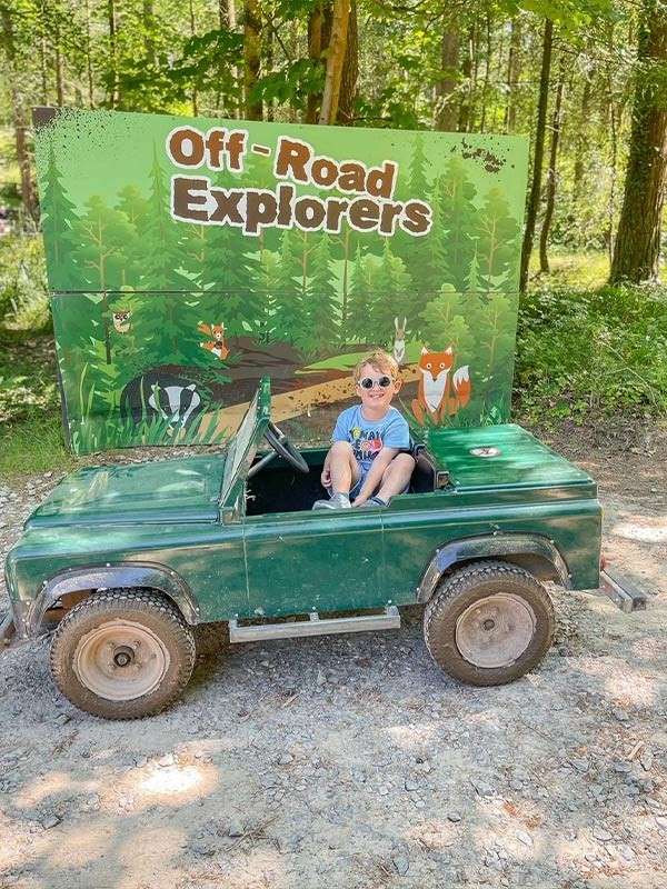 A child sat in an off road explorer car.