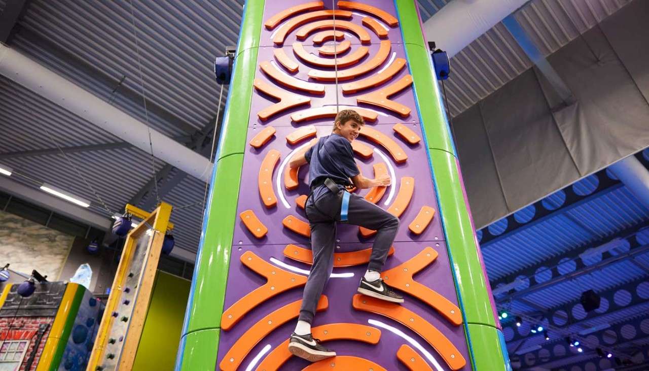 Man reaching the top of an indoor climbing wall