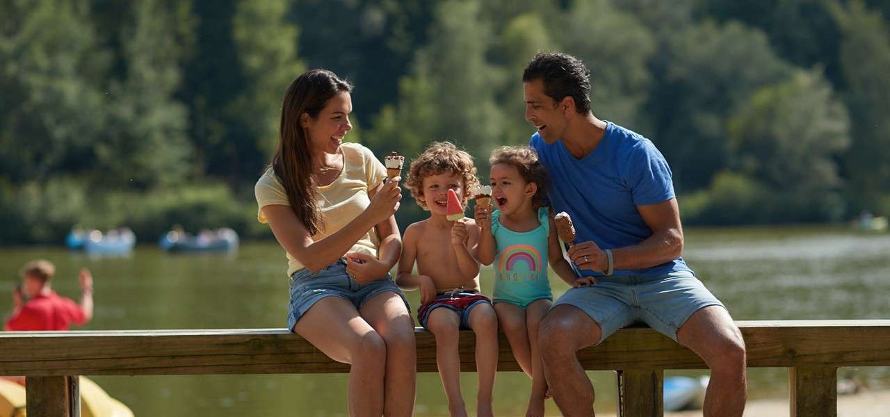 A family eating ice cream on the beach.