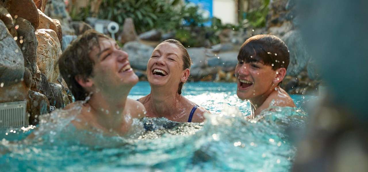 Teenage boys and mother in Subtropical Swimming Paradise going down the rapids