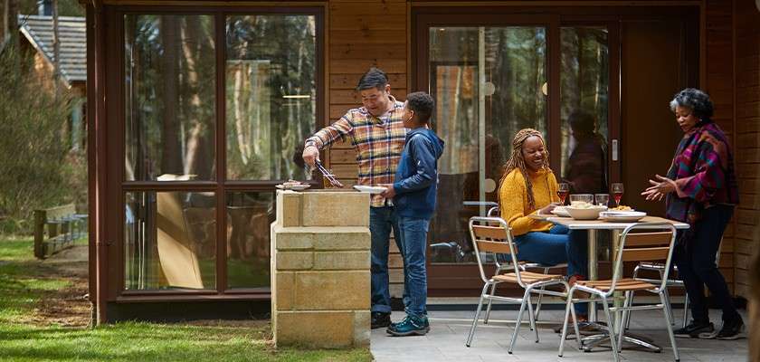 A family having a bbq outside their lodge