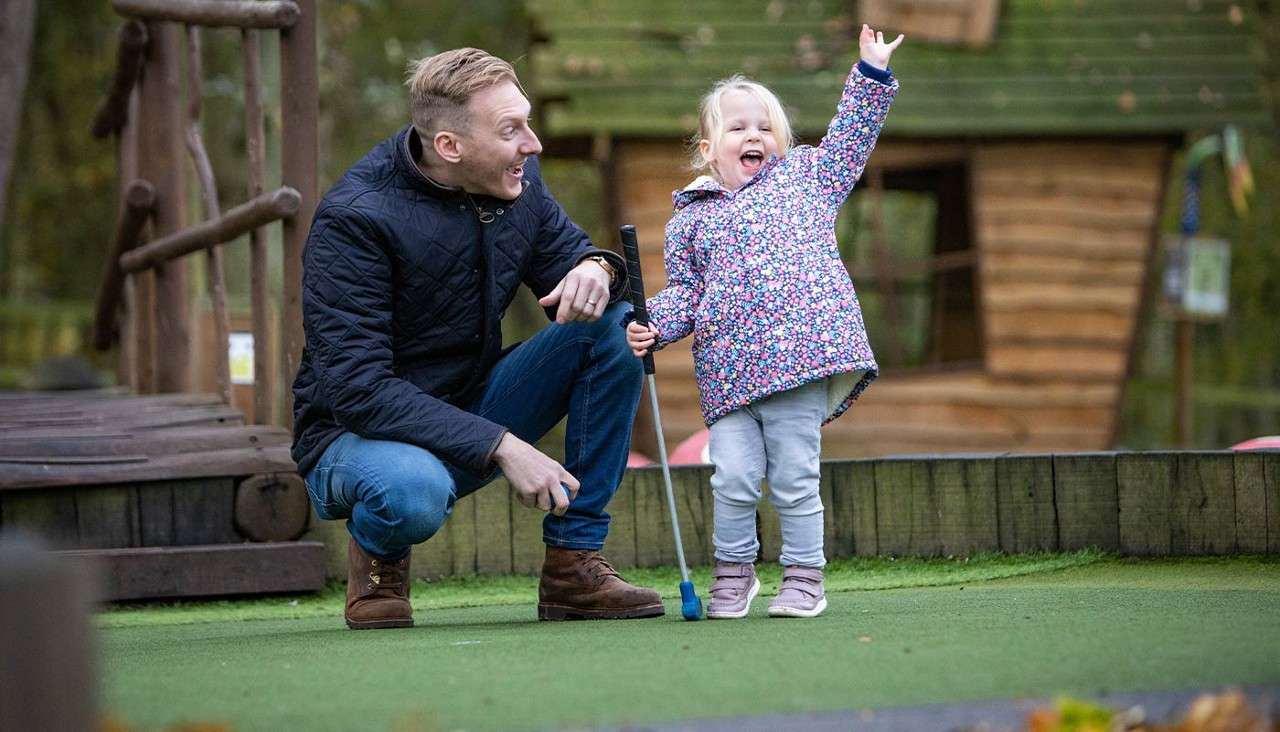 Father and daughter playing adventure golf