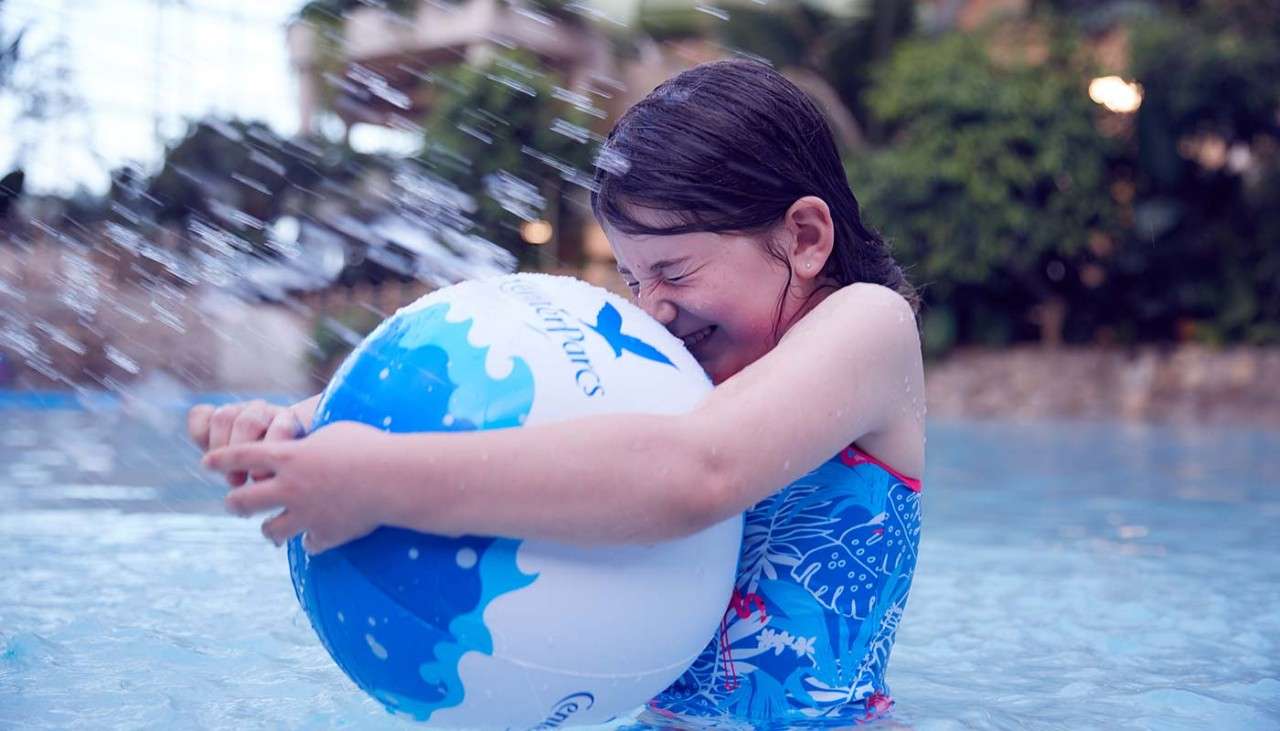 Girl playing with an inflatable ball in the Subtropical Swimming Paradise