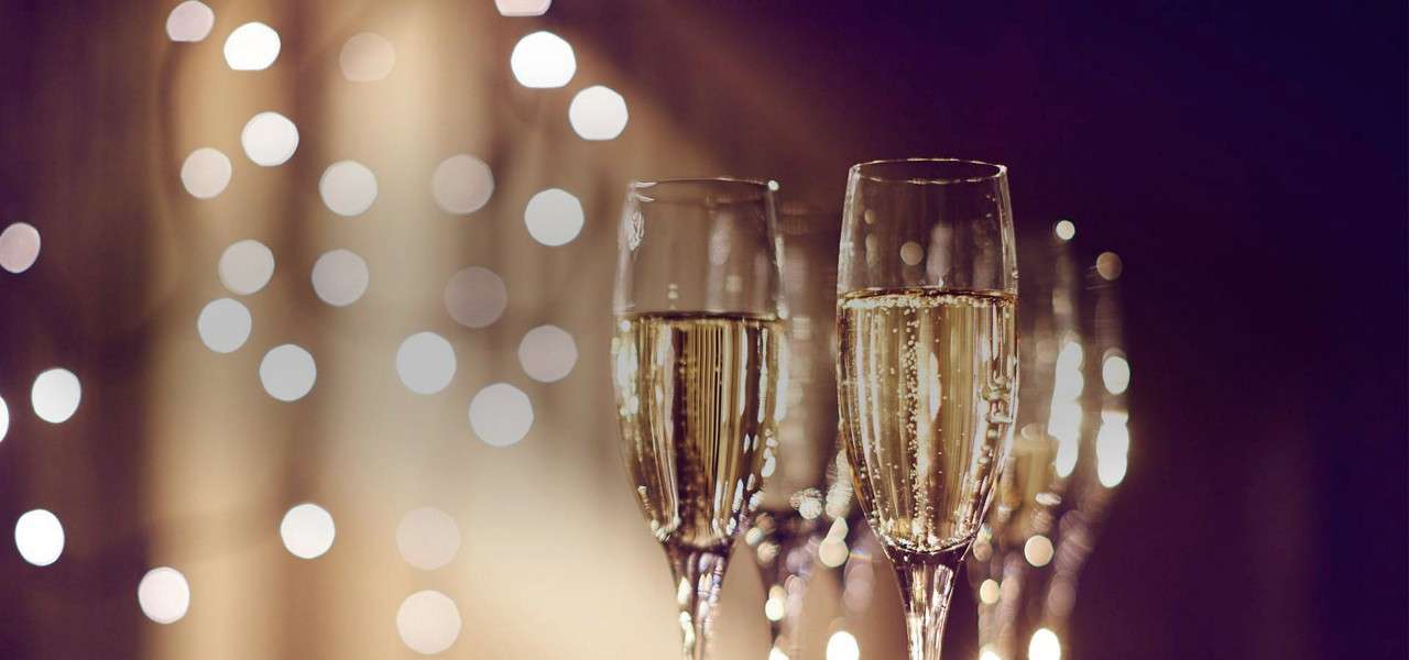 Two glasses of champagne with sparkling lights in the background