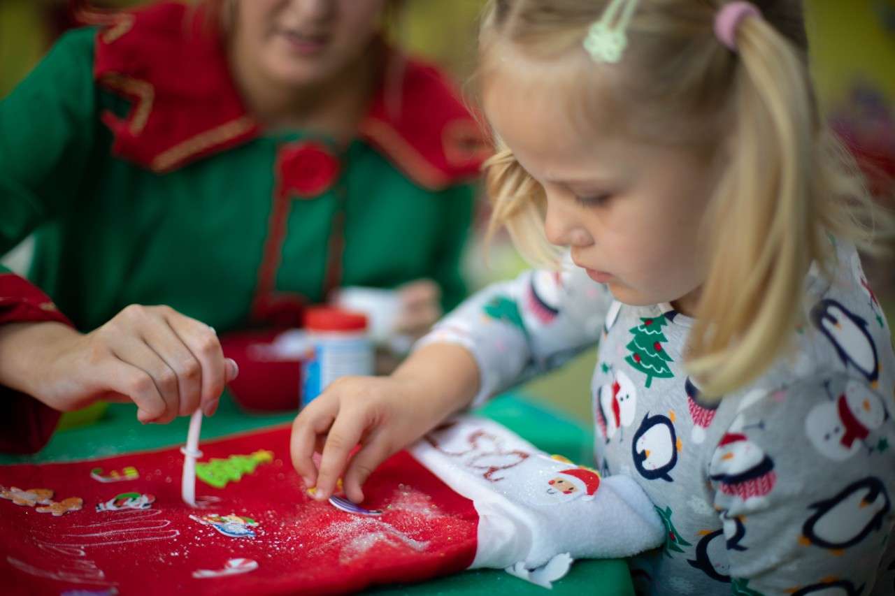 Girl decorating a giant Christmas stocking