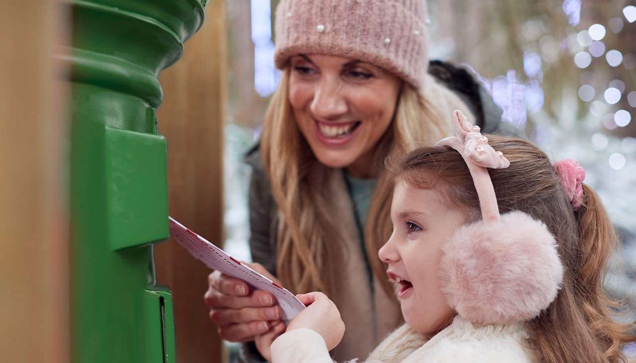 A little girl posting a letter to Santa