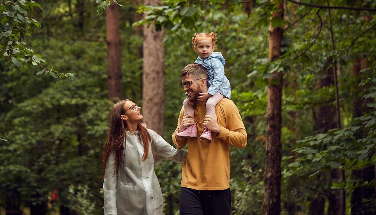 Father walks with his daughter up on his shoulders 