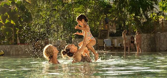A mother and grandmother holding a little girl in the air in the Subtropical Swimming Paradise.