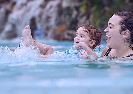 A mother playing with her daughter in the pool