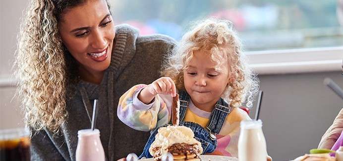 A toddler eating pancakes at the Pancake House