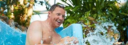 A man going down the slides in the Subtropical Swimming Paradise.