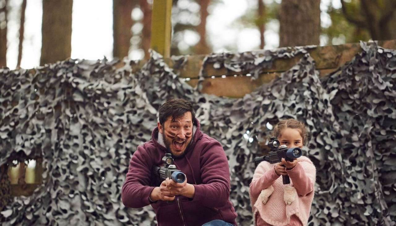 A dad and daughter playing Laser Combat