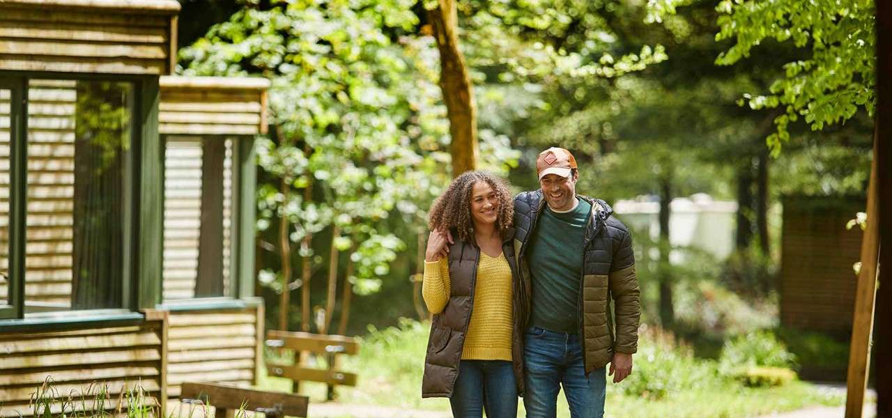 Pregnant couple walking through forest