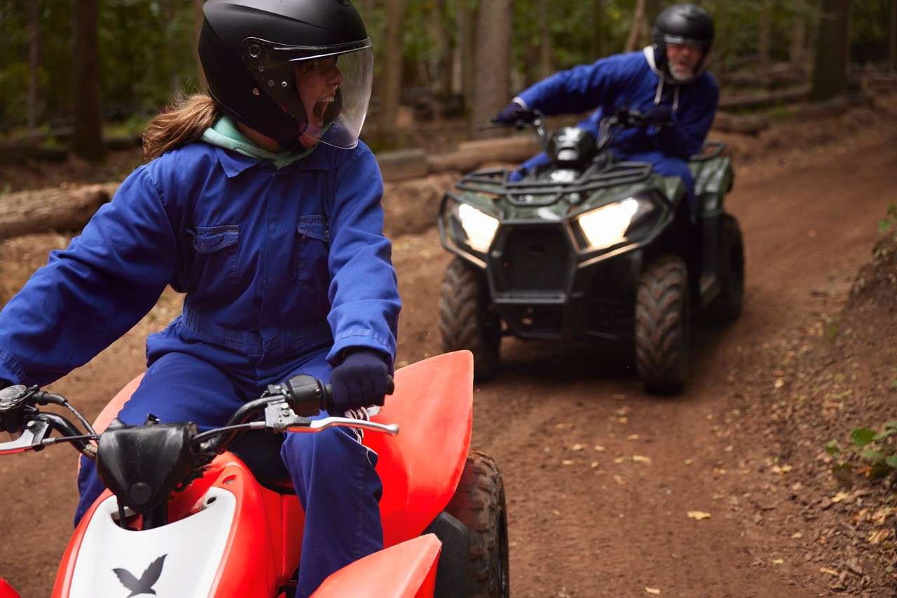 two quad bikes being ridden round a dirt track
