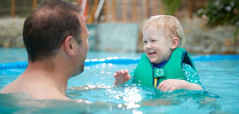 A father and son swimming in The Subtropical Swimming Paradise.