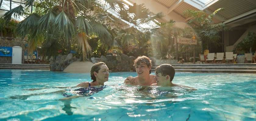 Teenage boys and mother in Subtropical Swimming Paradise going down the Lazy River.