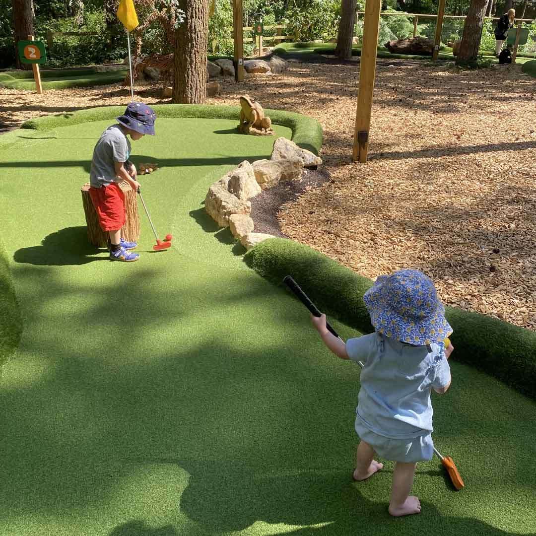 Two young children playing adventure golf