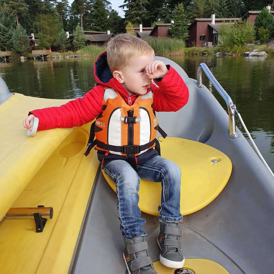 Young boy sitting on an Electric Boat on the lake.