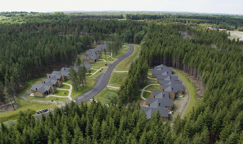 Aerial view of the lodges amongst the trees.