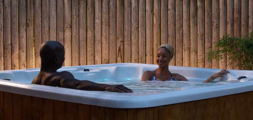 A husband and wife sitting in hot tub relaxing