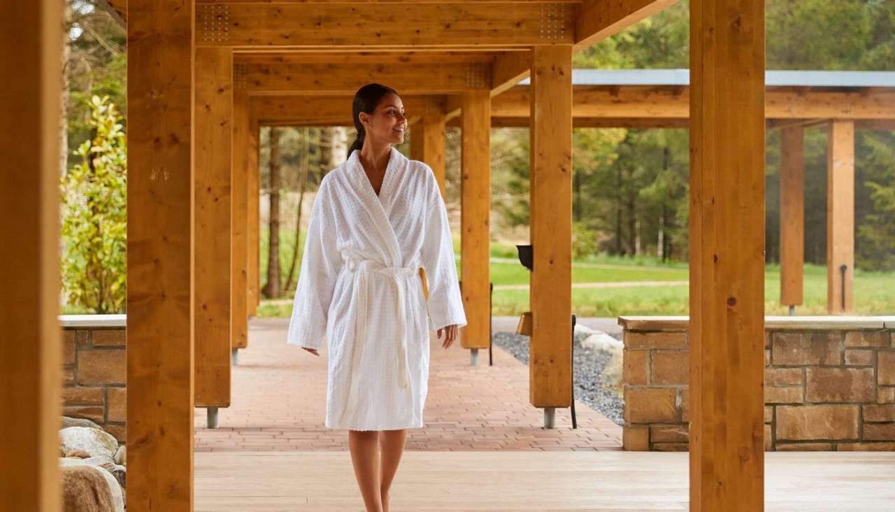 Woman walking in a bath robe by woodlands