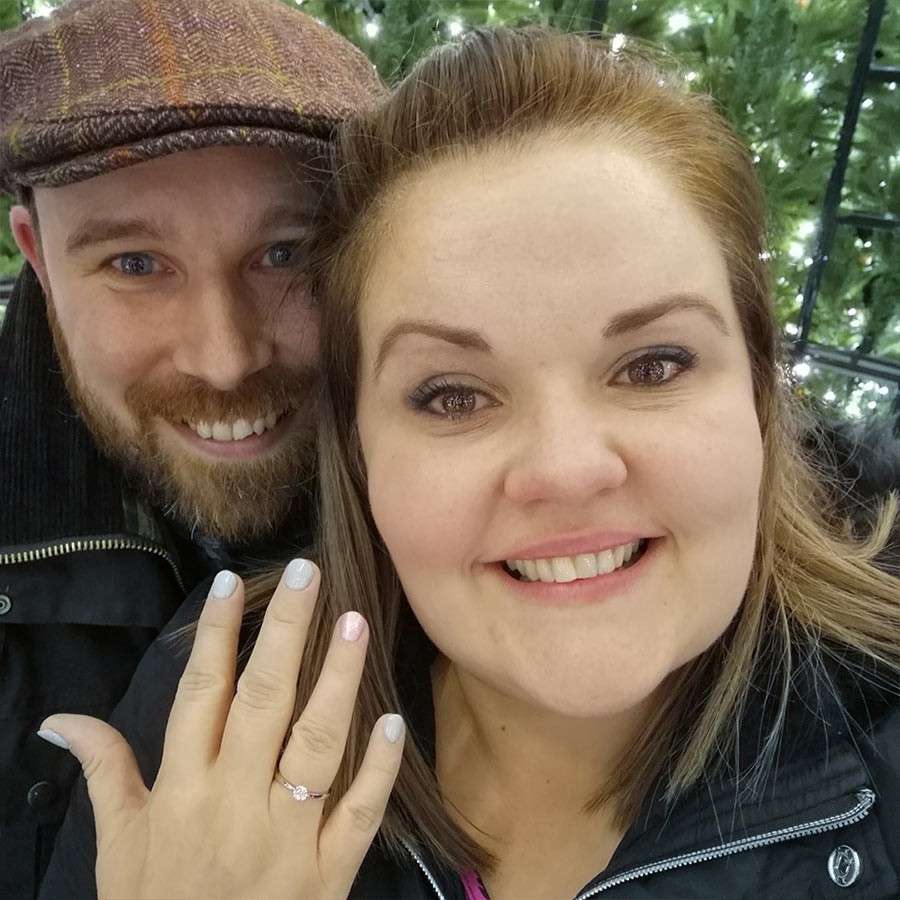 Woman showing off her engagement ring in a selfie with her partner