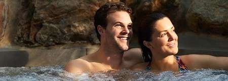 A couple sat together in a hot tub.