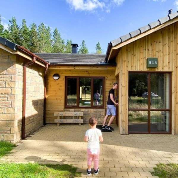 A boy and dad outside of their lodge