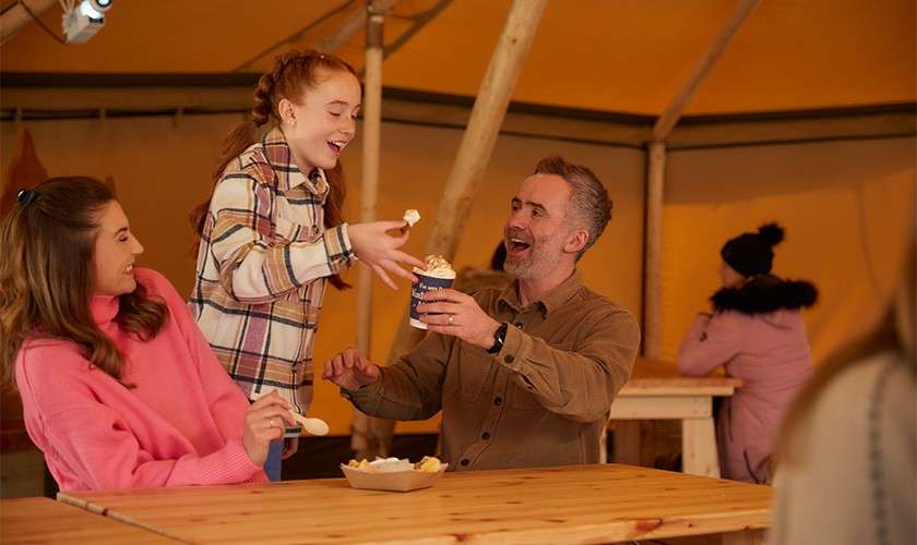 A family in the Tipi with hot chocolates.