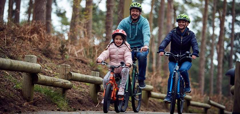 Family riding bike in woods