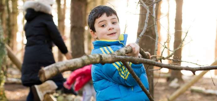 Young boy building a den.