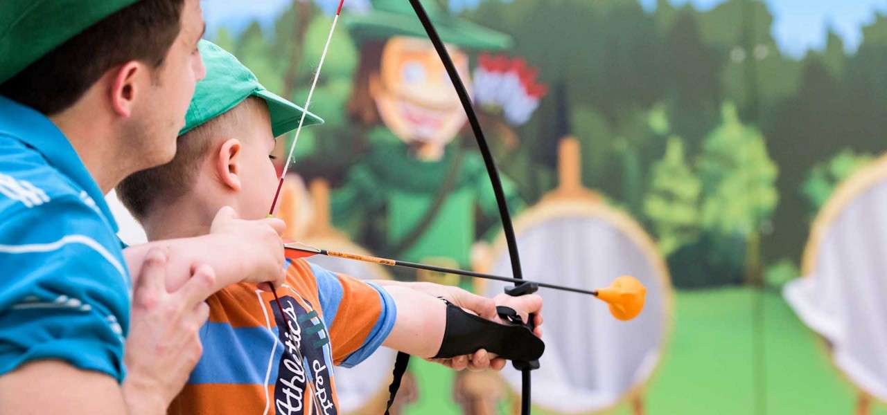 Dad and son with bow and arrow aiming for a target