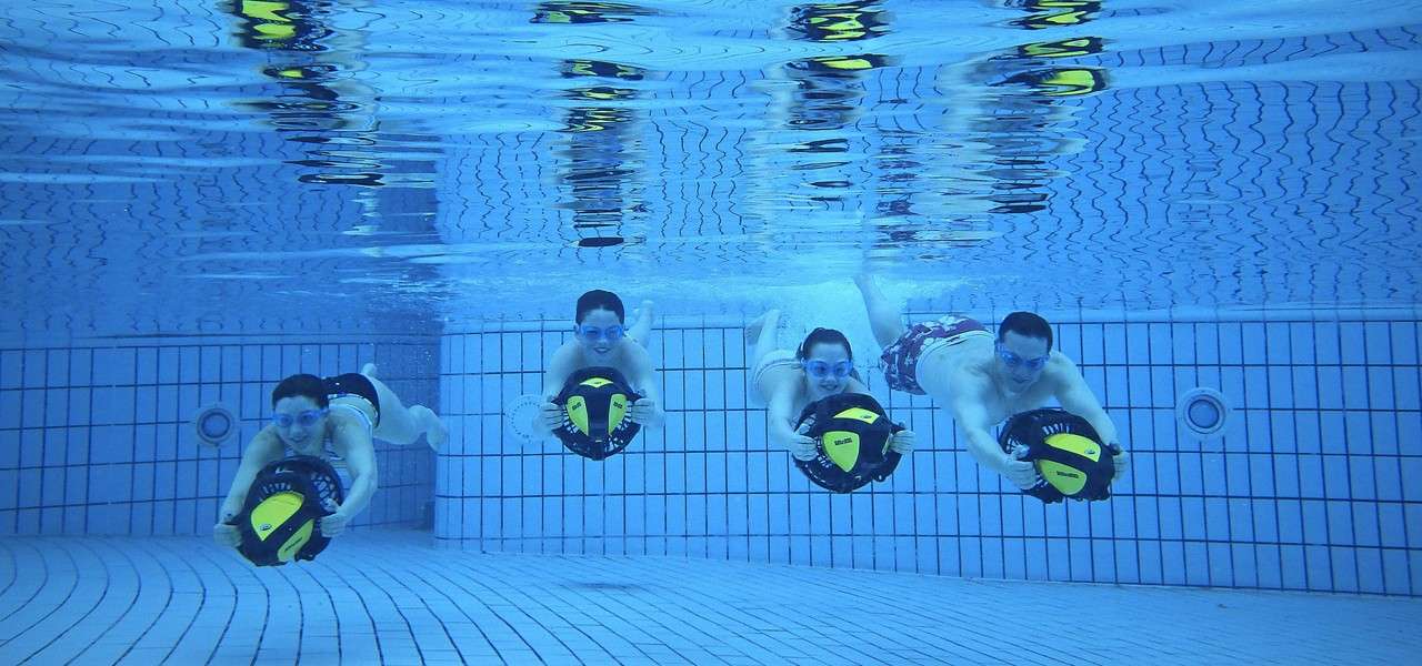Family of 4 under the water in the pool