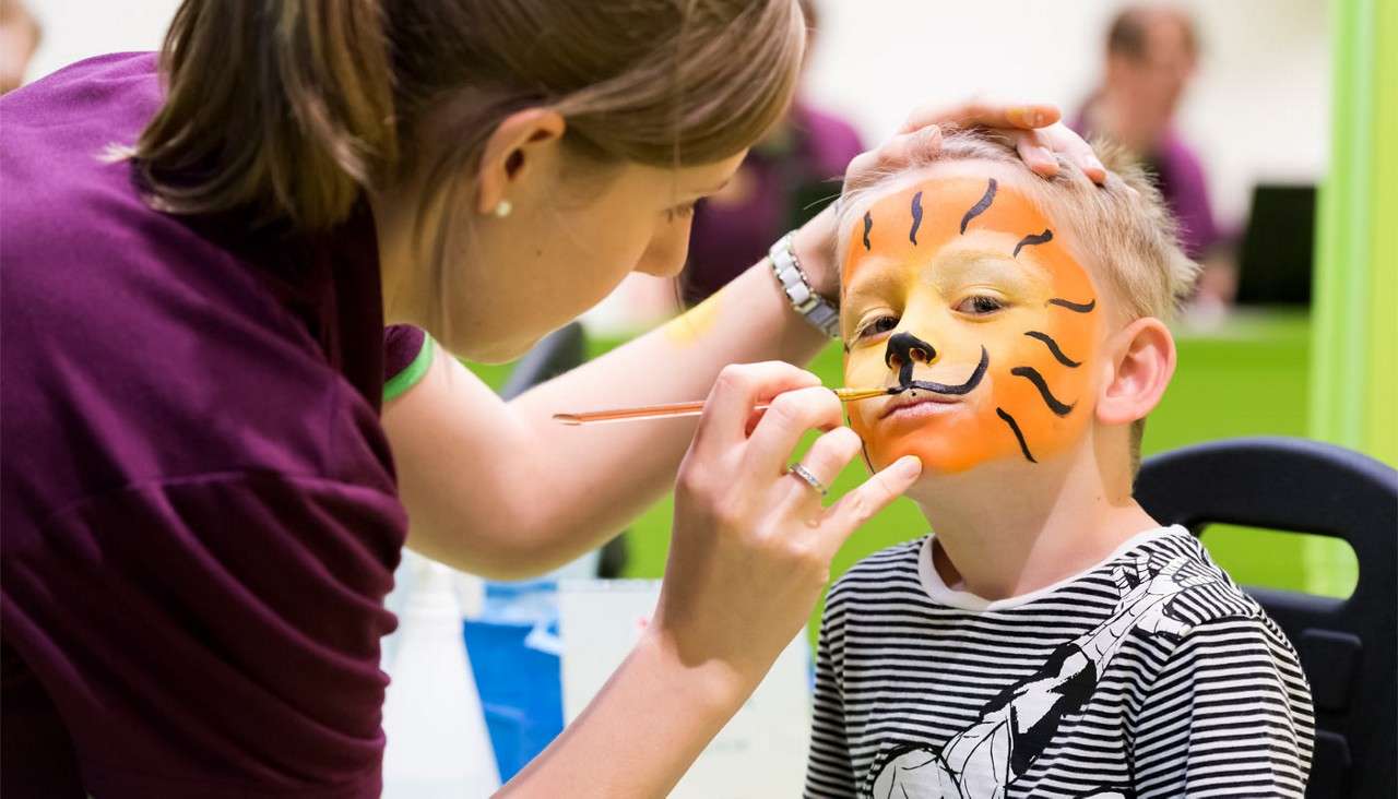 Young boy having his face painted 