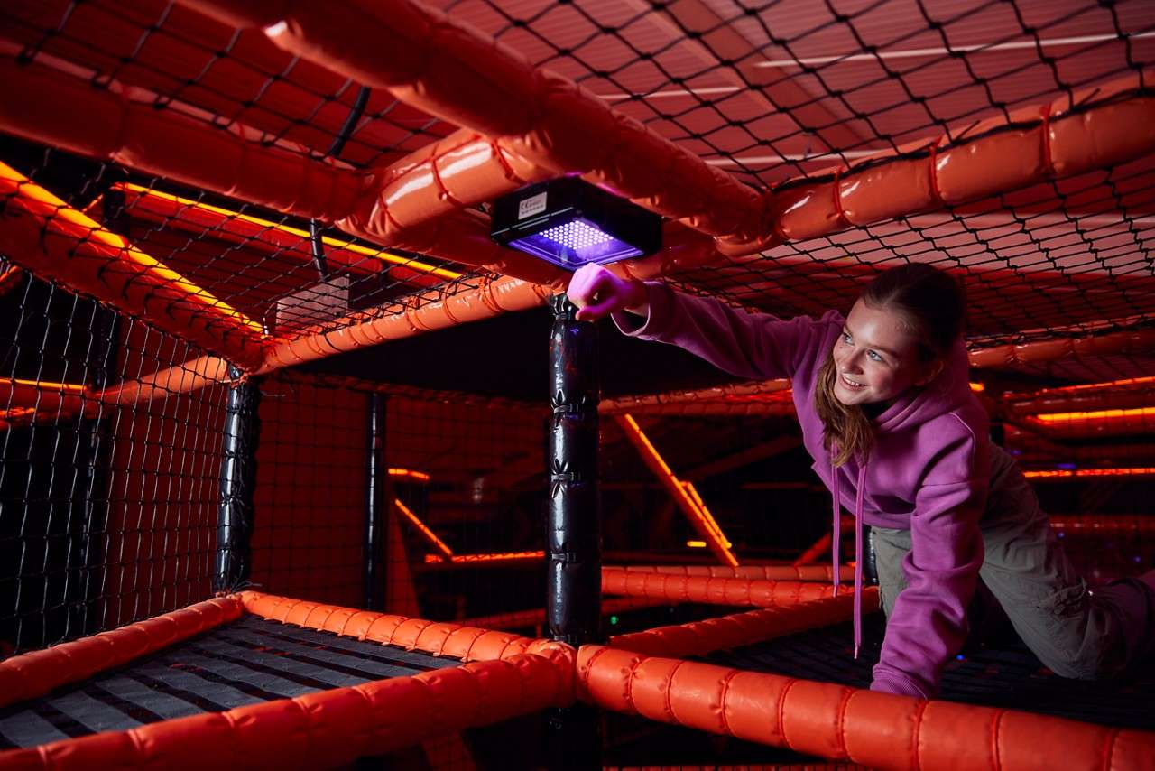 Young girl climbing through the TAG Challenge Arena.