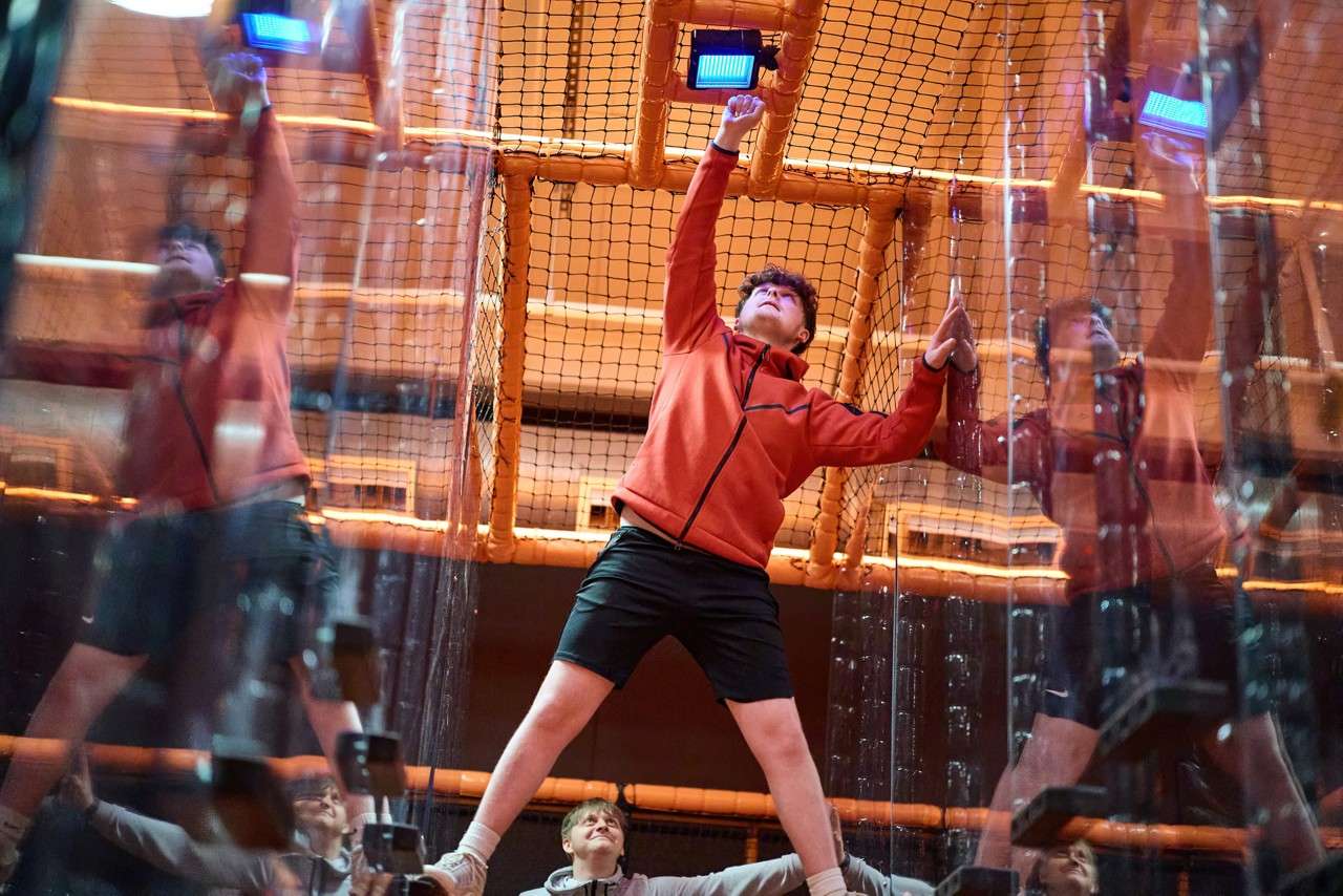 Young boy reaching for a buzzer inside the TAG Challenge Arena.