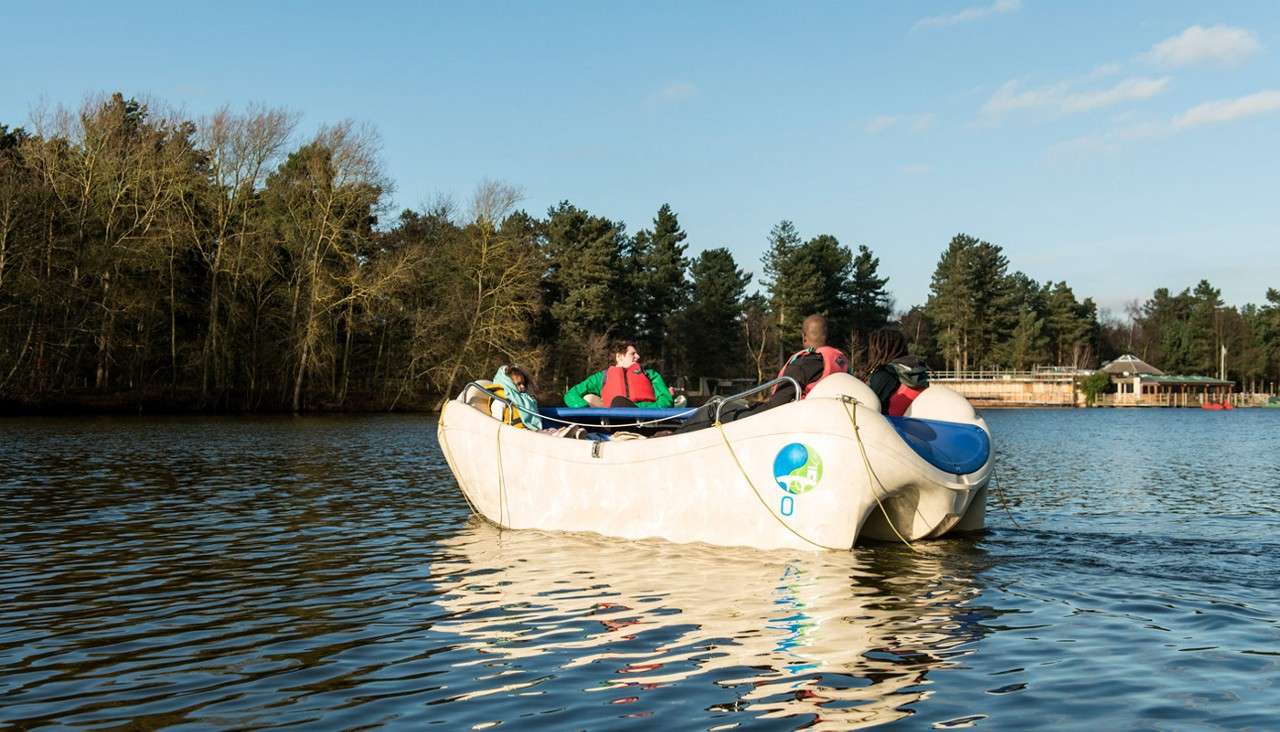 Group of people sitting in an Electric Boat on the lake.