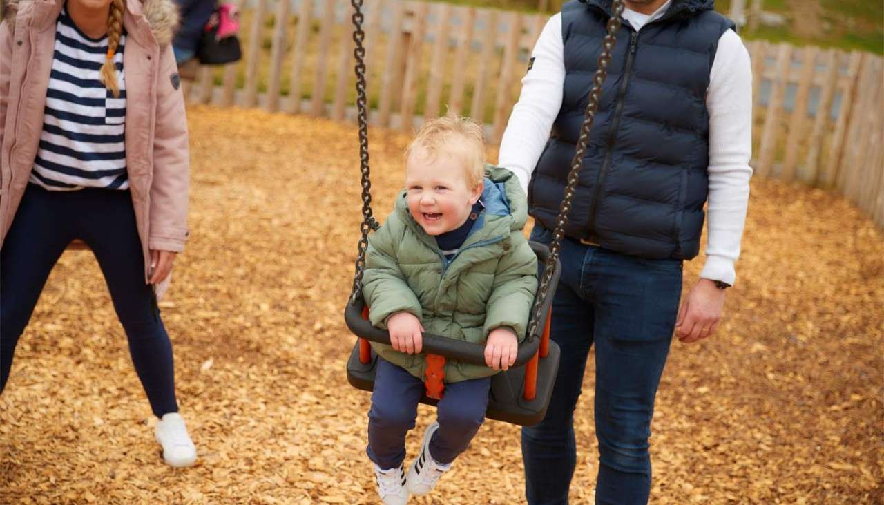 Young boy in a swing on an outdoor play area