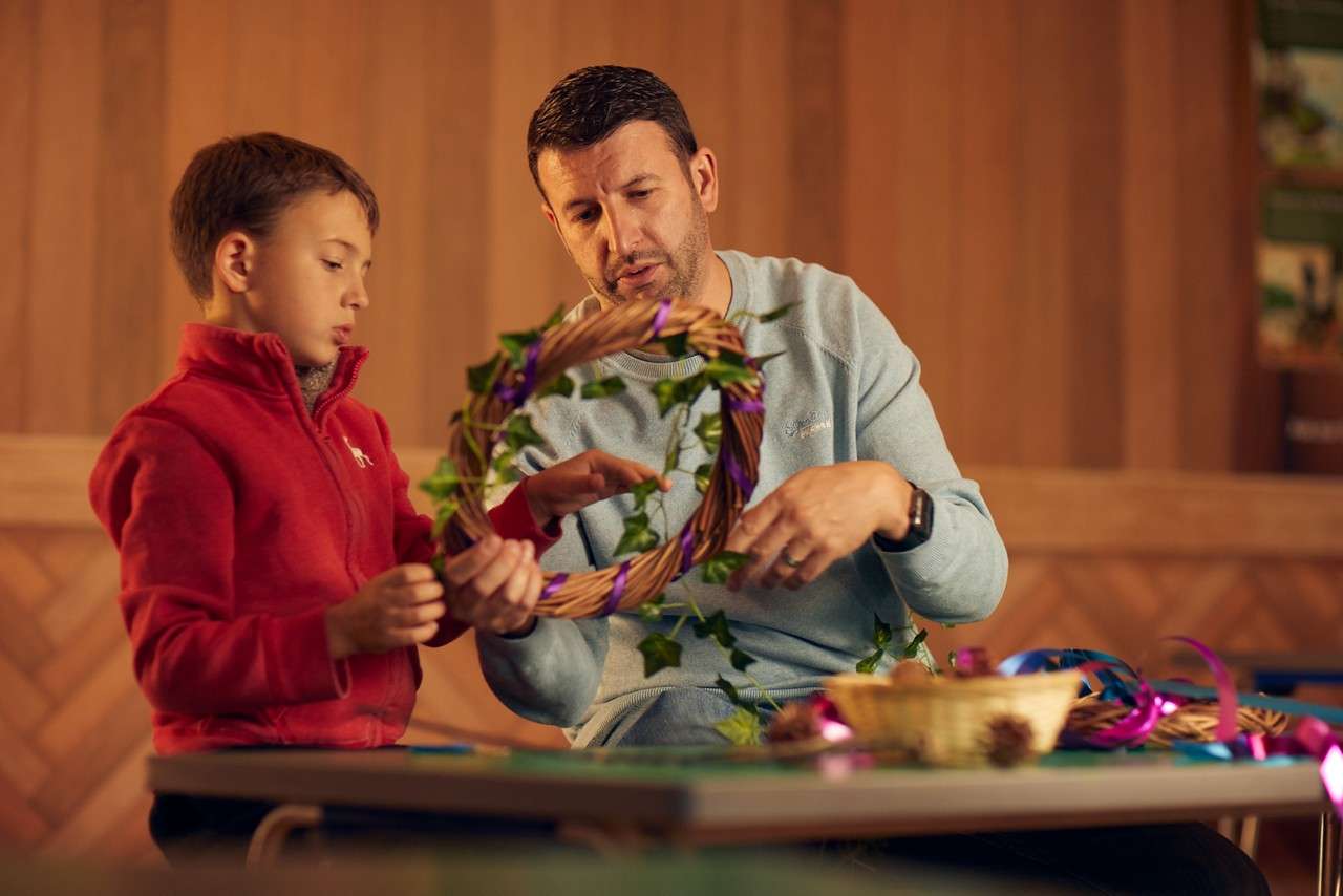 Two people doing some willow weaving.