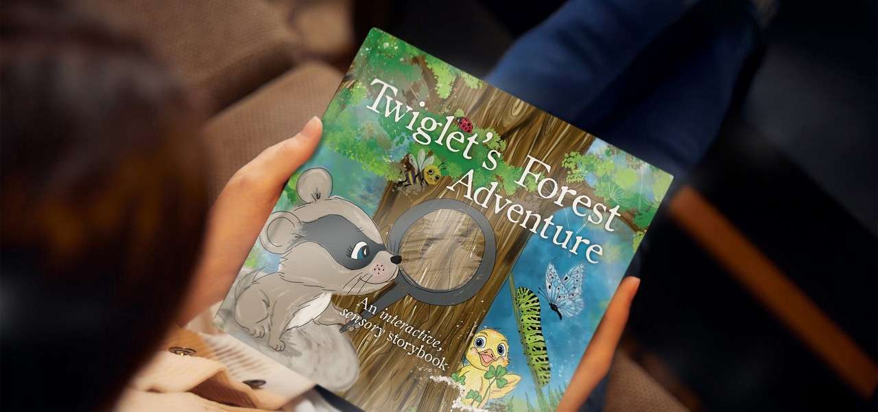 Girl holding a book called 'Twiglet's Forest Adventure'.