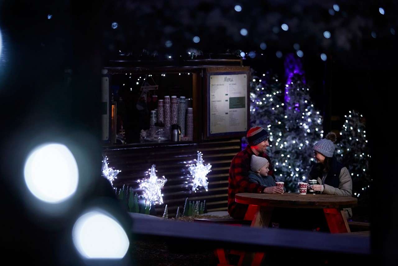 Family sitting around a table near the Forest Fayre.