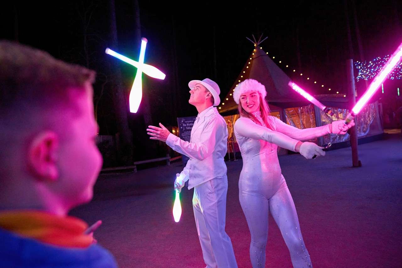 Juggling performers with glow in the dark battons.