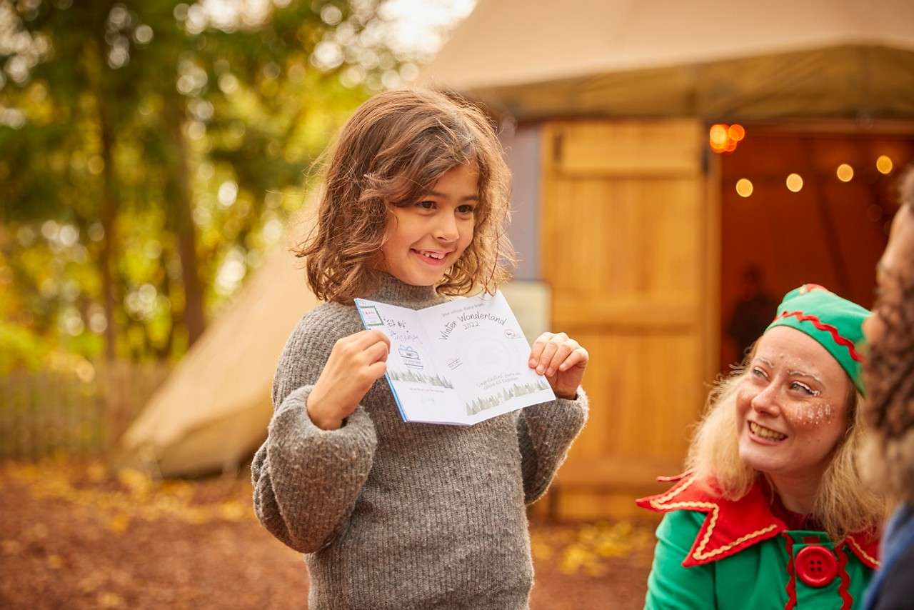 Young girl showing a piece of paper to an elf.