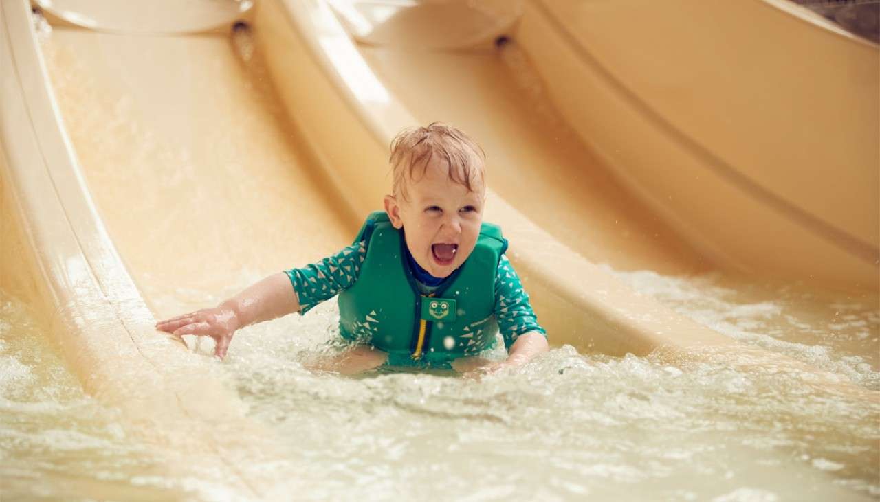 Boy sliding down water slide
