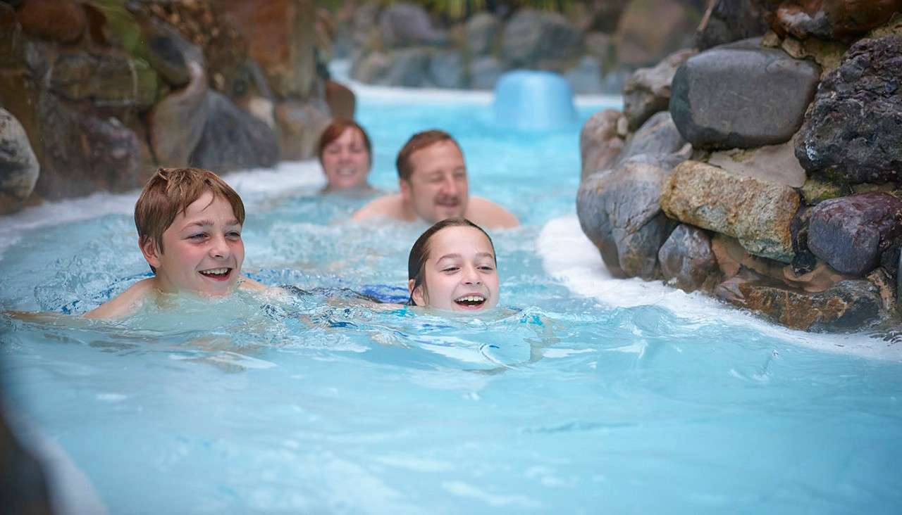 Group of young people swimming down the Wild Water Rapids.