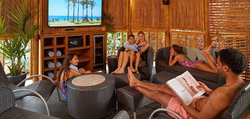 A family relaxing together in the family cabana at the Subtropical Swimming Paradise