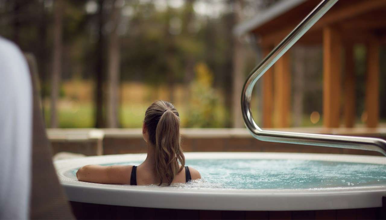 A woman sitting in an outdoor hot tub at the Aqua Sana Spa