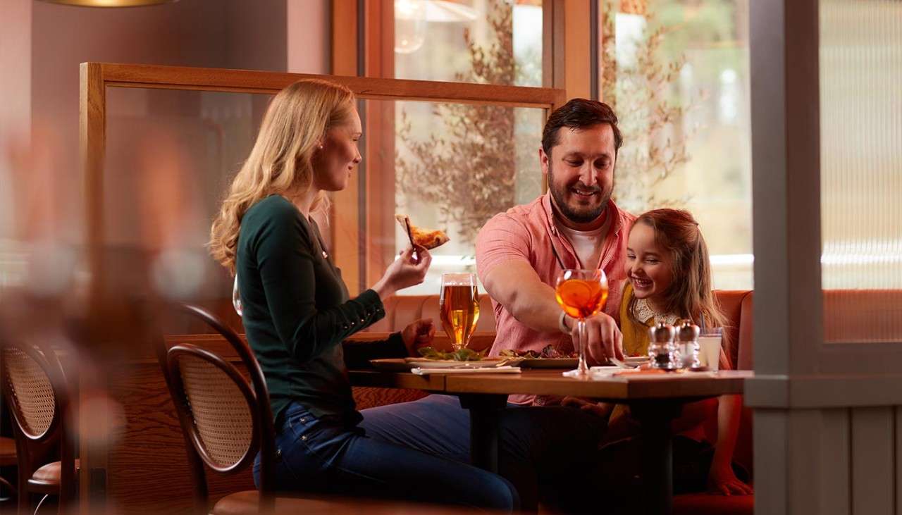A family eating a pizza in a restaurant 